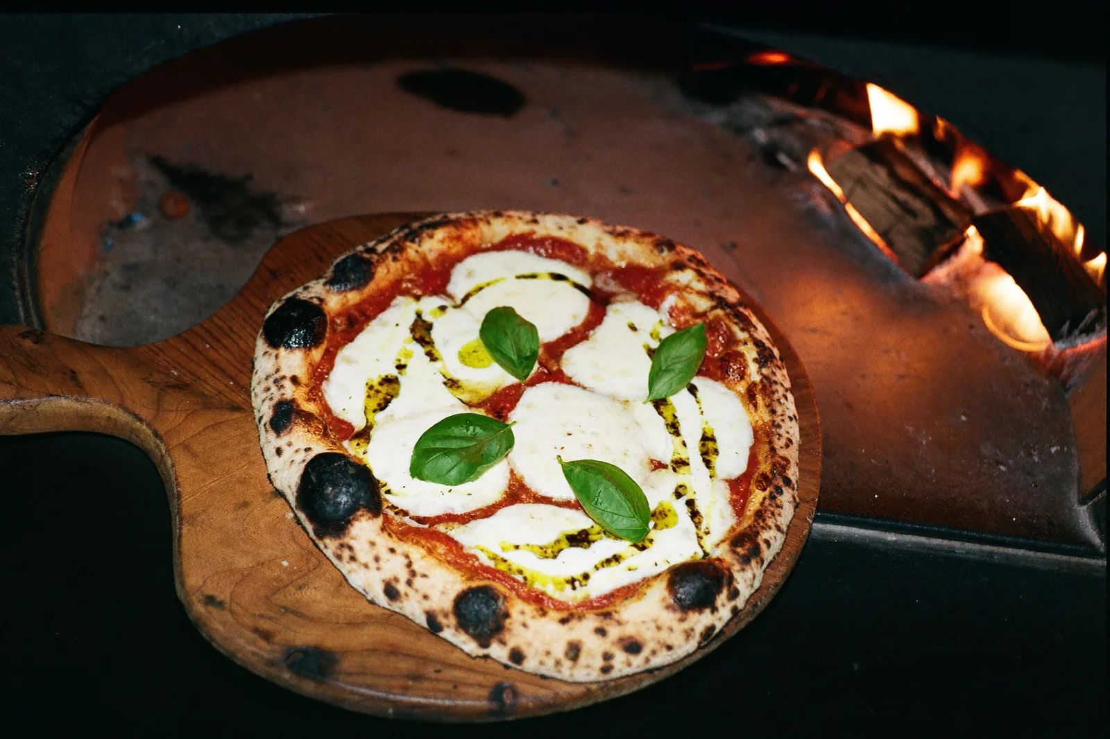 Pizza Margherita mit Basilikum am Feuer (Symbolfoto)